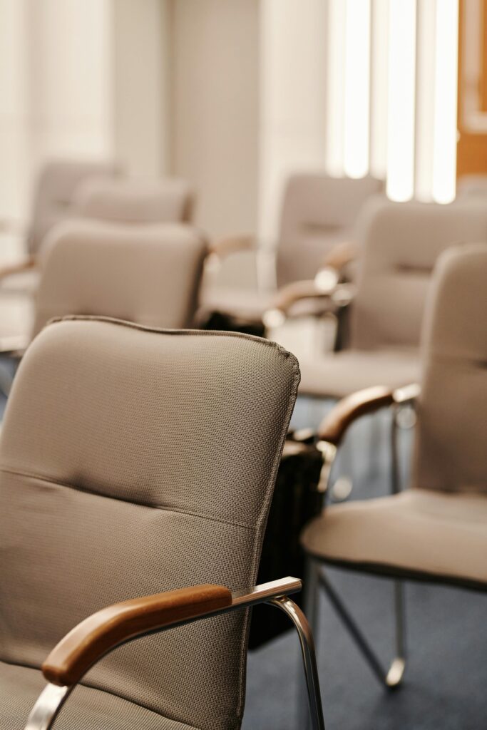 pexels photo 8354765 8354765 Modern beige armchairs in an empty conference room setting, vertical shot.